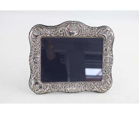 Hallmarked 1997 Birmingham silver photograph frame (452g) with scrolling leaf detailing and flower head boarder Maker - Ari D