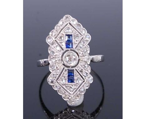 An Art Deco white metal lozenge shaped sapphire and diamond cluster ring, featuring a centre Old European cut diamond within 