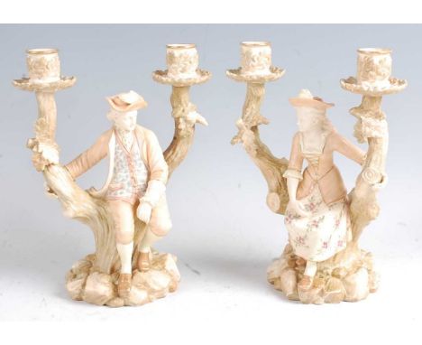 A pair of late 19th century Worcester porcelain candelabra figures after Watteau, the male and female seated on a treestump i