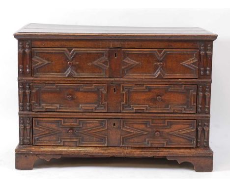 A Jacobean period oak chest, of three long geometric moulded drawers, having replacement turned wooden knobs and raised on la