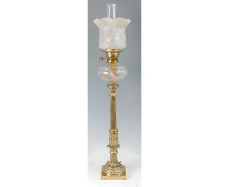 A Victorian brass pedestal oil lamp, having an acid etched shade over cut clear glass font, to a reeded acanthus leaf cast co