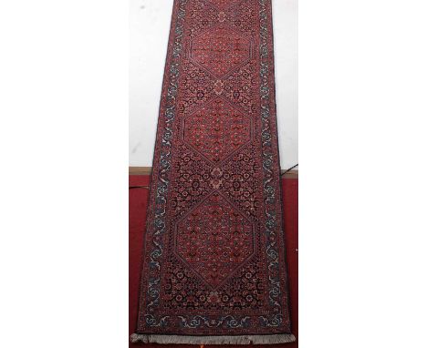 A Persian Bidjar woollen hall runner, the blue ground decorated with five lozenge medallions within trailing tramline borders