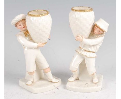 A pair of Hadley Worcester figures in the Kate Greenaway style, each modelled as a child holding a wicker basket aloft, heigh