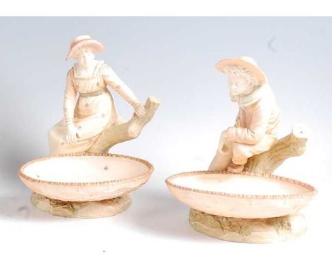 A pair of Hadley Worcester comports, each modelled as lone figure seated on a treestump, shape numbers 1153 and 1178, impress