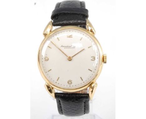 A Gents 18ct yellow gold IWC Schaffhausen manual wind wristwatch, having round cream Arabic dial and fitted to a black leathe