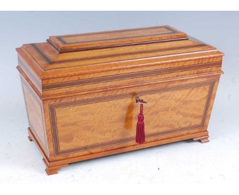 A late Victorian satinwood tea caddy, of sarcophagus form, having rosewood crossbanding, fitted interior of two lidded canist