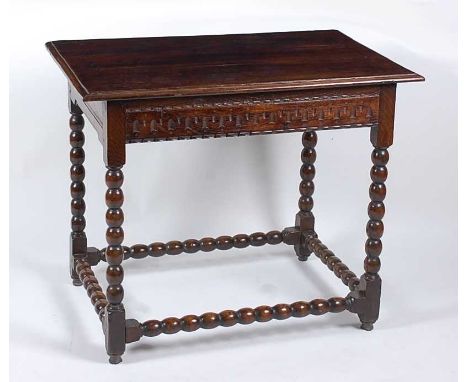A circa 1700 joined oak side table, the three-plank top with a moulded edge over a thumb-cut frieze, on bobbin turned support