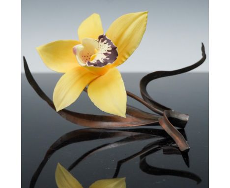 Delicate Boehm porcelain sculpture featuring a yellow orchid with rich burgundy detail at its center, gracefully supported by