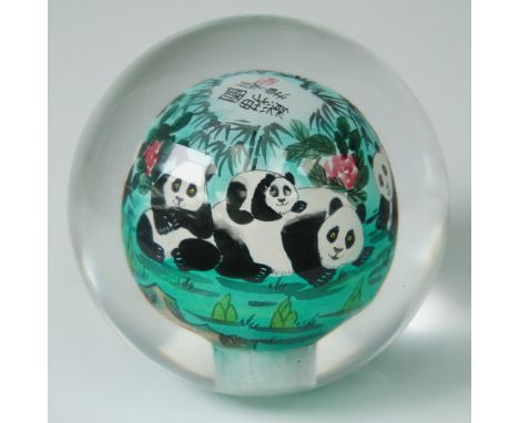 A beautifully crafted Chinese reverse inside painted crystal paperweight featuring a charming tableau of pandas surrounded by