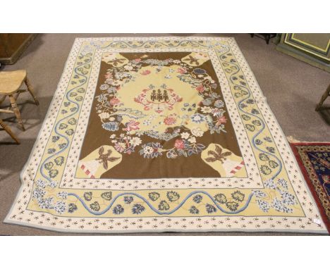 A woven tapestry woollen rug. The central yellow medallion on a brown ground and surrounded by floral borders, 297cm x 230cm