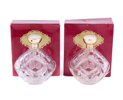 Two Lalique Le Baiser glass perfume bottles. Featuring a scene of a couple kissing, the stoppers decorated with flowers, in t