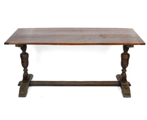 A Jacobean style oak plank top dining table. The twin plank top above carved cup and cover legs on sledge 'H' stretchers. H77