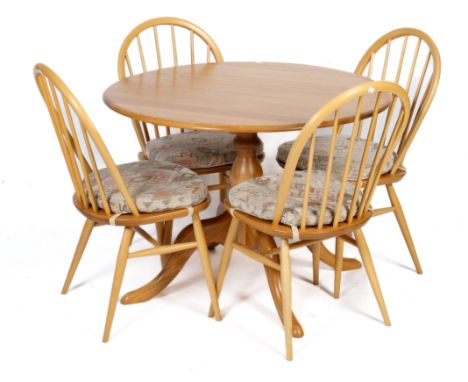 An Ercol blond table and four matching hoop back chairs. The table of circular form, mounted on a single pedestal base, H73cm