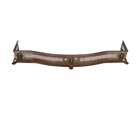 A Victorian serpentine fire fender. Featuring pierced decoration with lion head masks and claw feet. H20cm x W152cm x D40cm