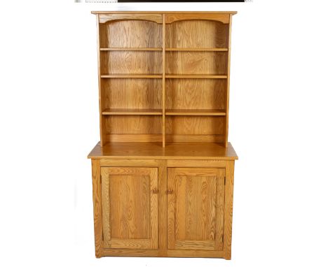 An Ercol blonde elm dresser. Having adjustable shelves above a two door cupboard opening to reveal a single drawer and three 