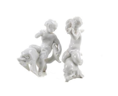 A pair of Bing & Grondahl Denmark blanc de Chine figures. Modelled as children riding dolphins, one blowing a horn, H20cm