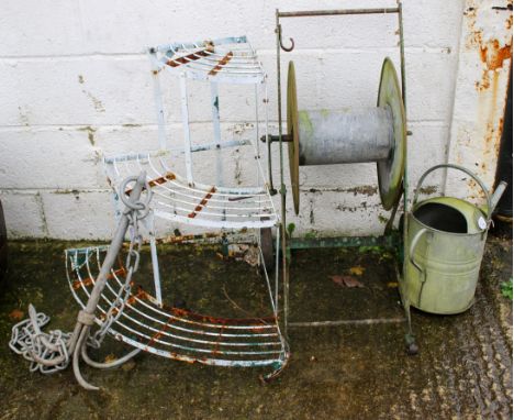 An assortment of garden metalware. Including a metal framed plant stand, an anchor, watering can, etc. H74cm