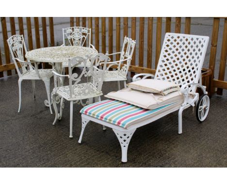 An assortment of cast metal garden furniture. Comprising a patio table and four chairs plus a sun lounger. Max. H83cm