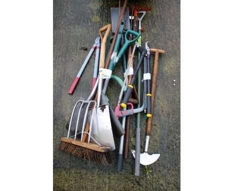 An assortment of gardening tools. Including spades, pitchforks, rakes, saws, etc.