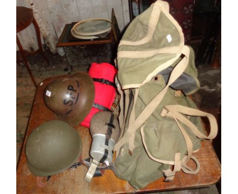 Tin helmet, WW2 army rucksack (1944), bed roll and flasks, and a U.S. helmet