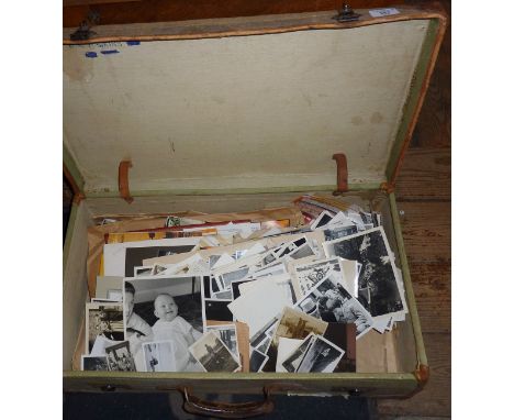 Vintage suitcase containing old black and white family photos, press photos and other ephemera