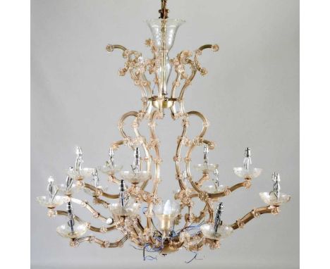 An ornate gilt metal fourteen branch chandelier, of tiered design, suspended with cut glass drops, in a packing case94w x 94d