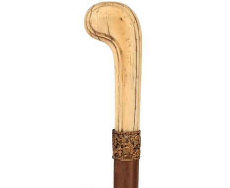 A LATE 19TH/EARLY 20TH CENTURY WALKING CANE, the ivory handle simply carved, yellow metal pierced collar, malacca haft, metal