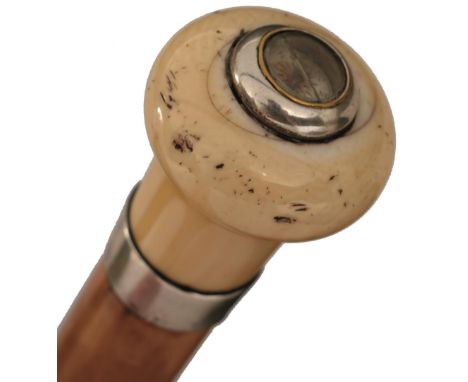 AN EARLY 20TH CENTURY GADGET WALKING CANE, the plain ivory pommel inset with a compass to the top, above silver collar hallma