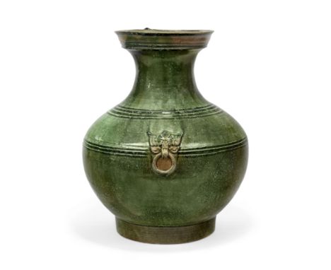 A green-glazed vase, huHan dynastyThe compressed globular body flanked by a pair of moulded handles each in form of mythical 