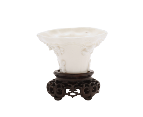 A Chinese Dehua libation vesselQing dynasty, Kangxi periodThe exterior moulded with a dragon and phoenix amongst clouds and p