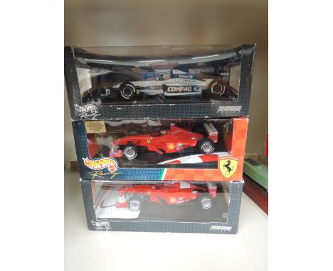 Three Hot Wheels 1:18 scale die-cast F1 racing cars, in original window display boxes