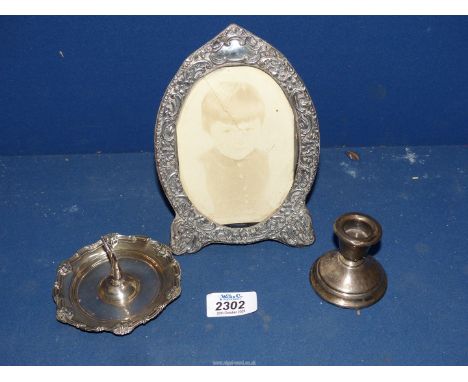 Three items of Birmingham silver, ring tree 27.4 gms. (a/f.), small weighted candlestick and silver photograph frame.
