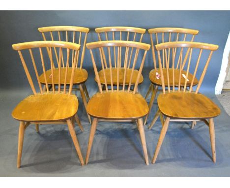 A Set of Six Ercol Blonde Ash Dining Chairs each with a stick back above a panel seat raised upon outswept legs with stretche