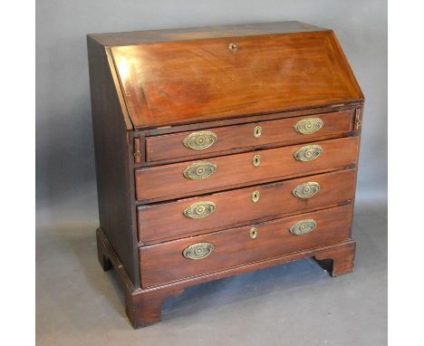 A George III Mahogany Bureau, the fall front enclosing a fitted interior above four long graduated drawers with brass handles