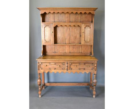 An 18th Century Style Oak Dresser, the boarded shelf back with two cupboard doors, the lower section with two moulded doors w