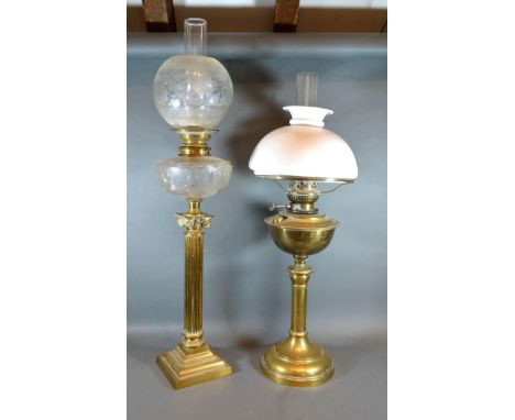 A Late 19th Early 20th Century Brass Oil Lamp of Corinthian Form with chimney and shade together with another similar brass o