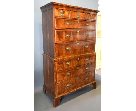 A George II Walnut Chest on Chest, the moulded cornice above three short and six long graduated drawers, the oval brass handl