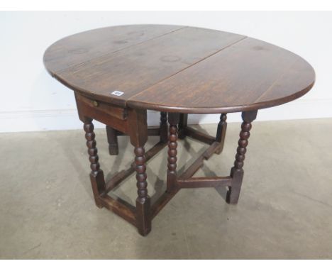 An 18th century oak gateleg table with a long drawer on bobbin turned legs - Height 68 cm x 1.1m x 90 cm 