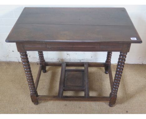 A late 18th early 19th century oak table of pegged construction with bobbin turned legs joined by stretchers with slide throu