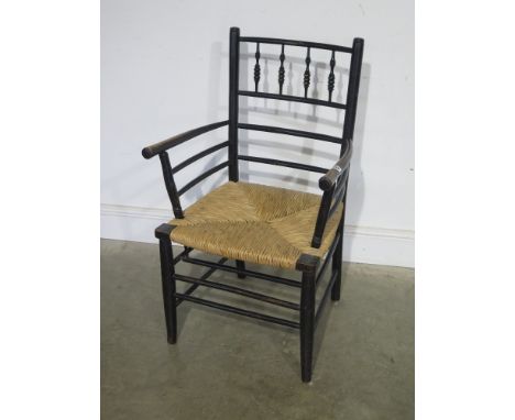 A William Morris design Sussex ebonised armchair with rush seat and bobbin back - probably Morris & Co