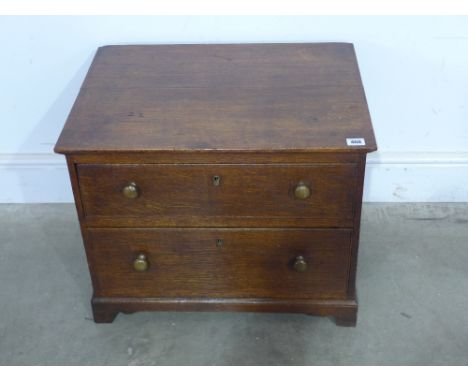 A small oak two drawer chest on bracket feet 59cm wide x 46cm tall x 44cm deep
