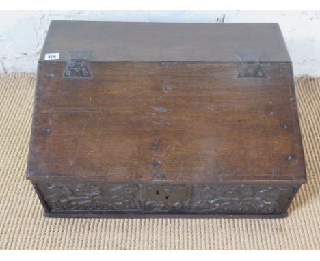 A late 17th century carved oak sloped box with hinged lid opening to reveal shelf to well, fruiting vines carved to front - H