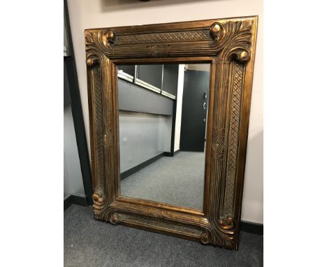 A contemporary overmantel mirror in a substantial gilt frame, 105cm by 136cm