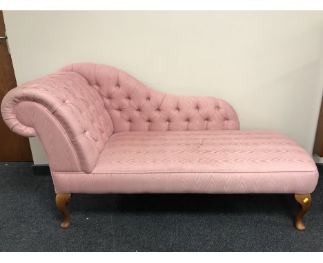 A contemporary chaise longue in pink button fabric 