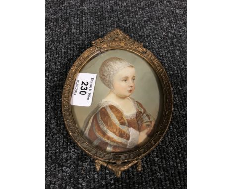 A gilt-framed oval portrait miniature depicting a young child sporting a bonnet and holding an apple, 10 cm x 12 cm. 