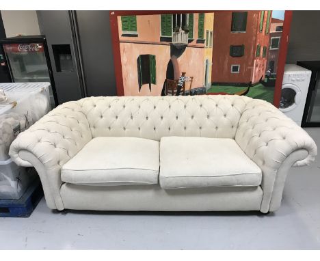 A three seater Chesterfield style settee upholstered in cream button fabric 