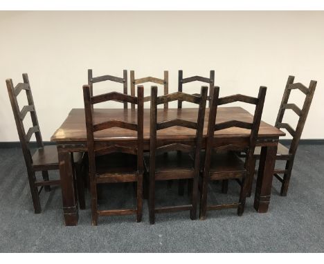 An Indonesian hardwood dining table and eight ladder backed chairs 