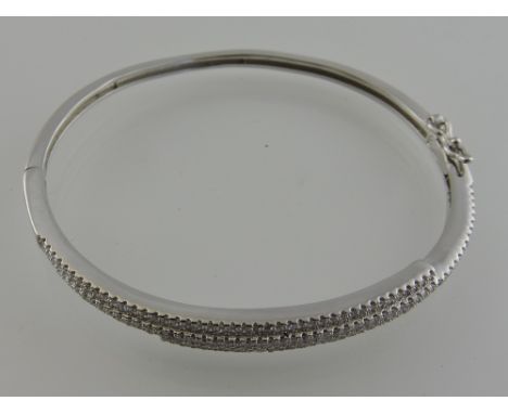 A silver and cubic zirconia bangle.