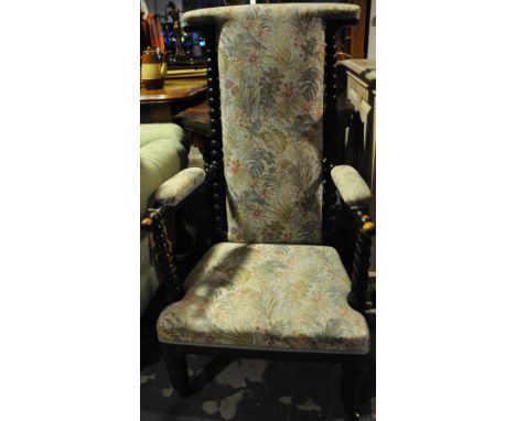 A Victorian upholstered prie dieu elbow chair with ebonised bobbin turned frame