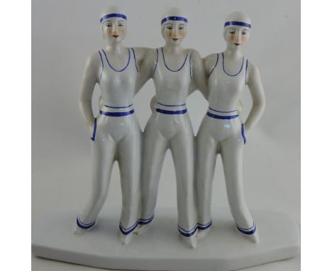 A ceramic Art Deco-style figure of three sailor girls.